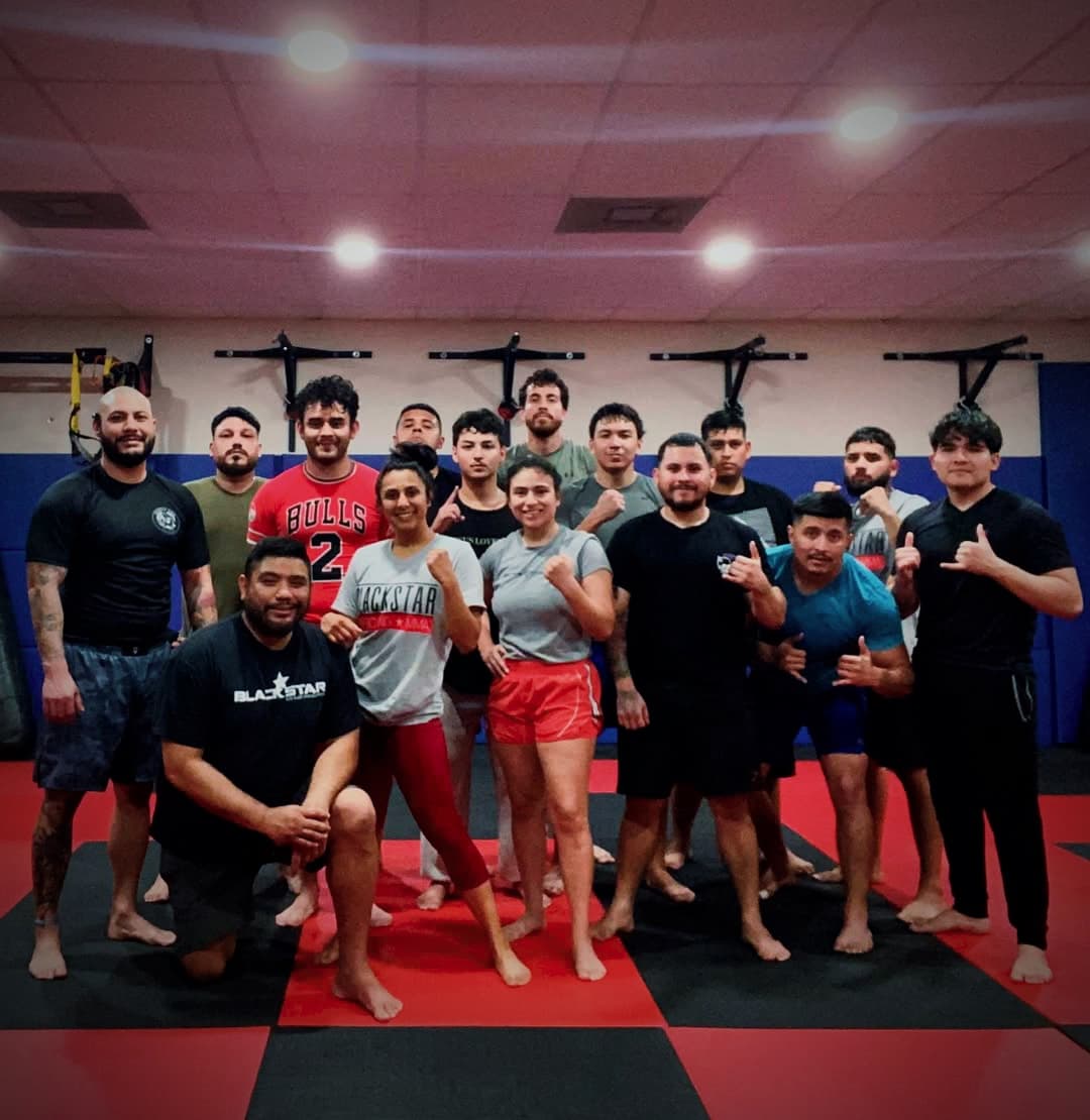 An adult class poses together after evening training