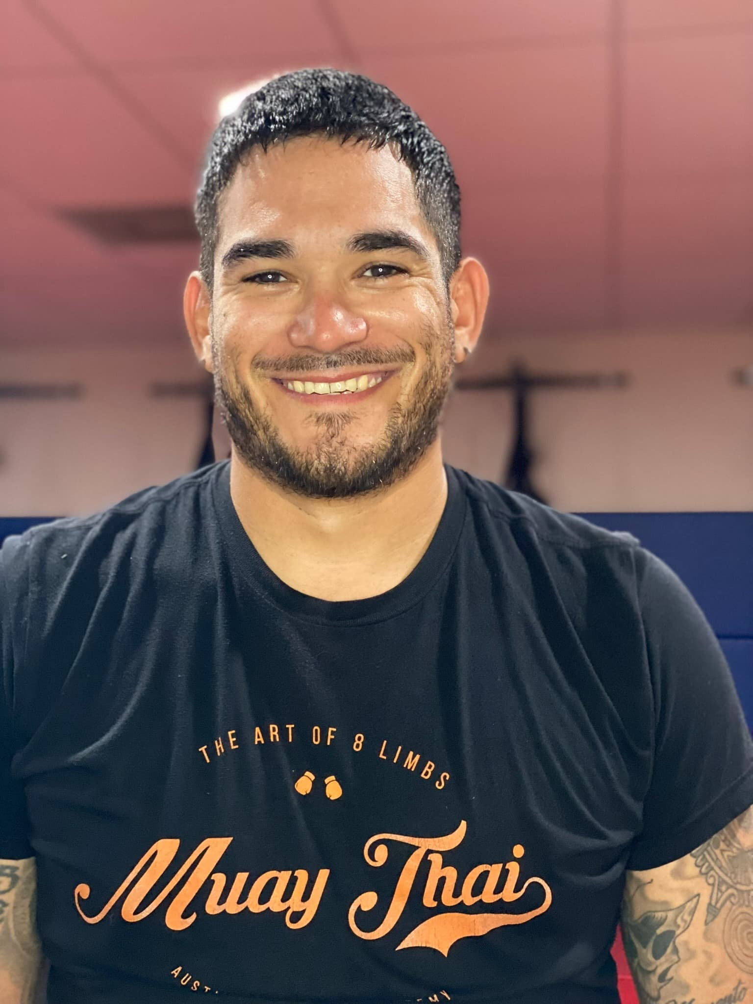 Carlos smiles in front of the blue wall pads