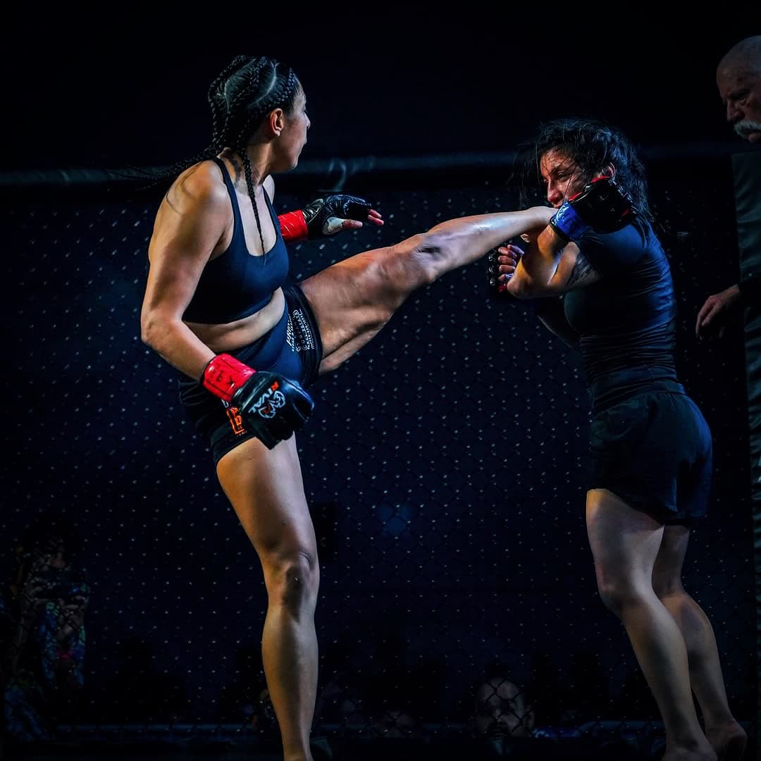 Two Blackstar fighters trade kicks inside the cage during a sparring session under low light