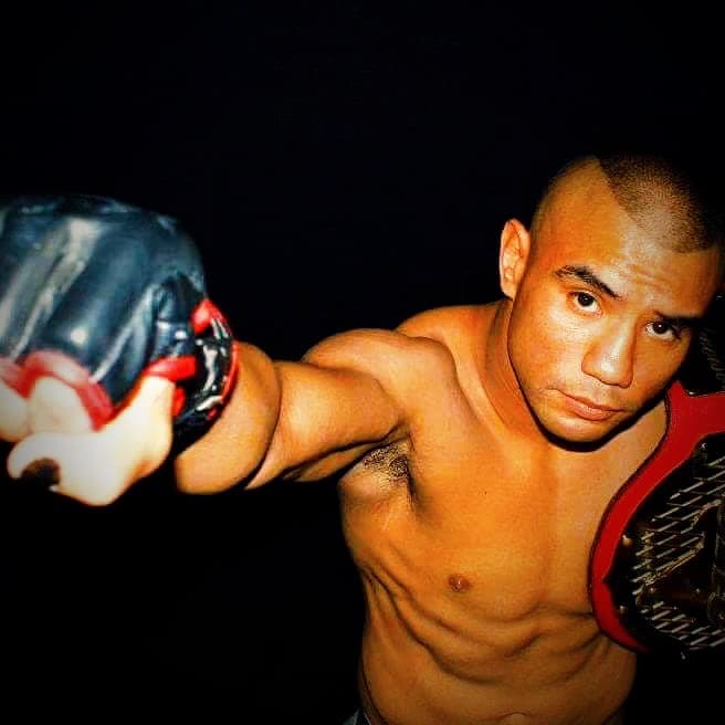 An archive photo of a young champion in gloves holding a title belt