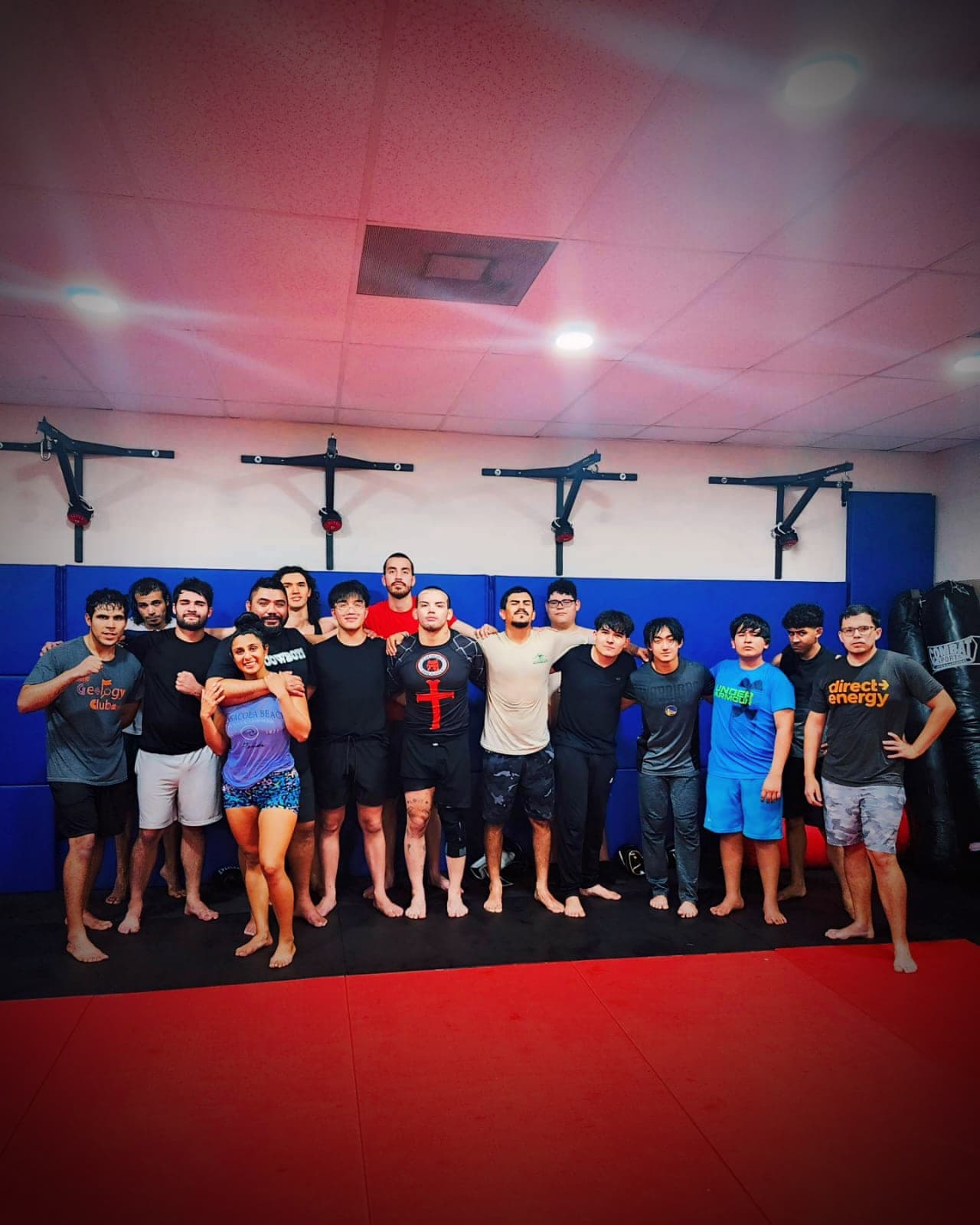 The Blackstar team huddles arm in arm on the mats